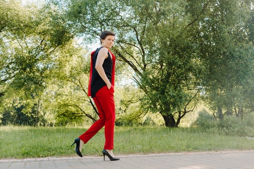 Portrait of a girl in a red suit standing in the alley of the park photo