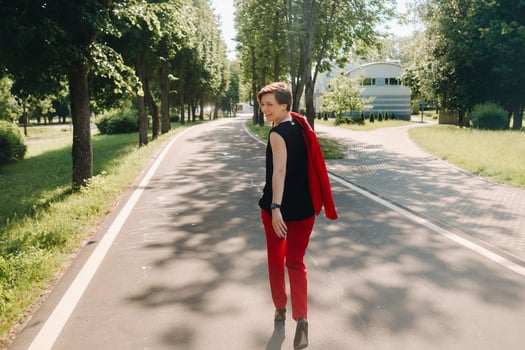 Portrait of a girl in a red suit standing in the alley of the park photo