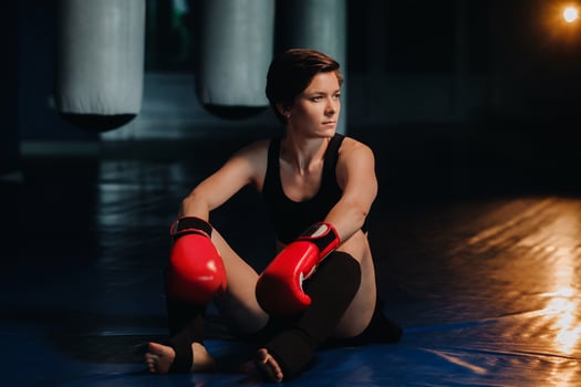 portrait of a female boxer in red gloves in the gym after training photo