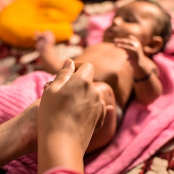 10 Months cute little Indian boy doing oil massage at home by his mother, cute little boy enjoying during oil massage, little toddler enjoying healthy massage by mother photo