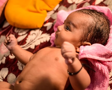 10 Months cute little Indian boy doing oil massage at home by his mother, cute little boy enjoying during oil massage, little toddler enjoying healthy massage by mother photo