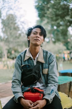 A Southeast Asian man wearing a denim jacket, standing and looking straight ahead photo