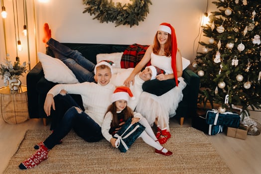 Close-up portrait of a happy family sitting on a sofa near a Christmas tree celebrating a holiday photo