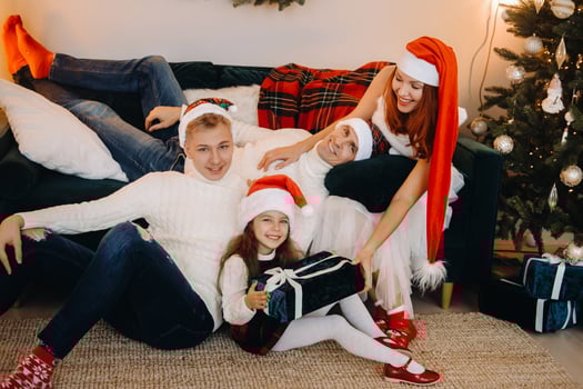 Close-up portrait of a happy family sitting on a sofa near a Christmas tree celebrating a holiday photo