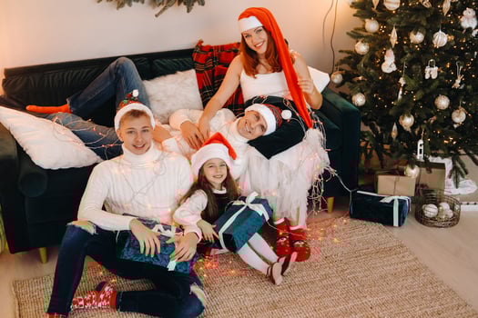 Close-up portrait of a happy family sitting on a sofa near a Christmas tree celebrating a holiday photo