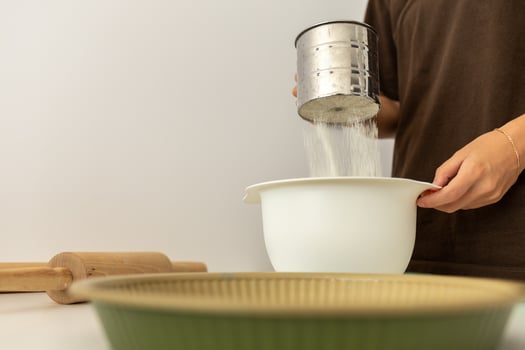 girl sifting flour for baking, cooking at home photo