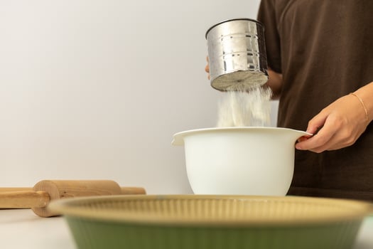 girl sifting flour for baking, cooking at home photo
