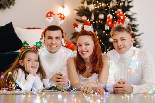 Close-up portrait of a happy family lying near a Christmas tree celebrating a holiday photo