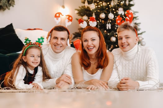 Close-up portrait of a happy family lying near a Christmas tree celebrating a holiday photo