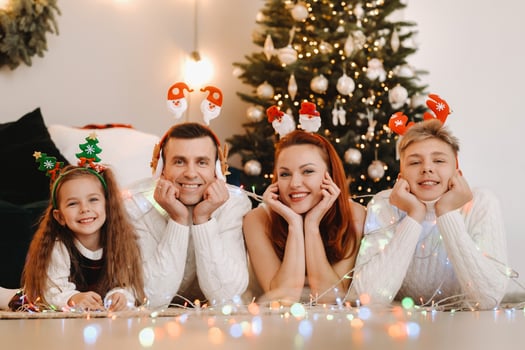 Close-up portrait of a happy family lying near a Christmas tree celebrating a holiday photo