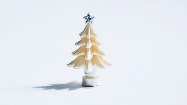 Small white Christmas tree ornament with a silver star on a white background photo