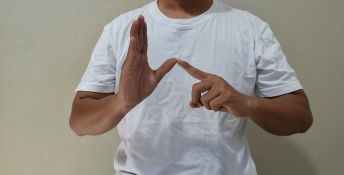 Young man shows sign language to talk. Hand gestures of people with hearing impairment photo
