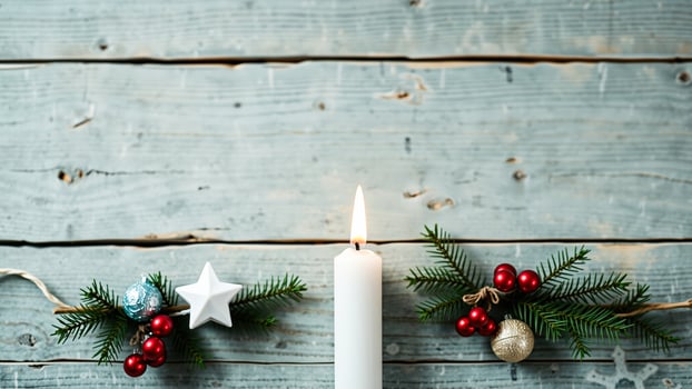 Burning Candle and Christmas Decorations on Weathered Wooden Background photo