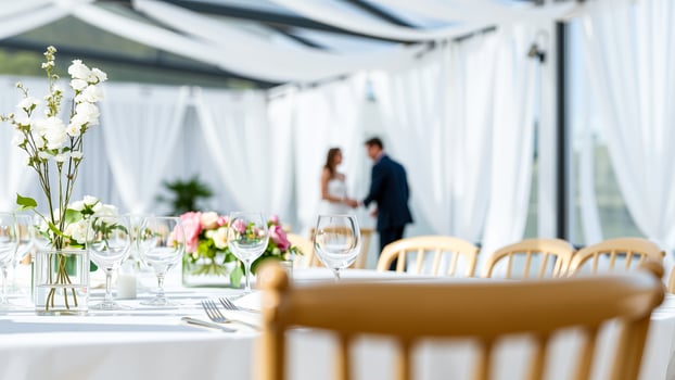 Wedding Reception Table Setting with Bride and Groom in the Background photo