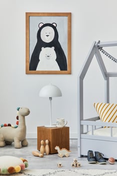 Stylish scandinavian child's room interior with mock up poster frame, creative bed, wooden cube, plush and wooden toys and hanging textile decorations. Grey walls. Template. photo