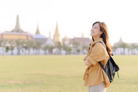 A Traveler Asian woman in her 30s exploring Wat Pra Kaew. From stunning architecture to friendly locals, she cherishes every moment, capturing it all in her heart and camera for years to come. photo