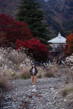 Asian woman in casual dress enjoys the beauty of fall in Japan, sharing smiles, selfies, and scenic views by the lake near Mount Fuji. A cheerful holiday portrait capturing the essence of joy. photo