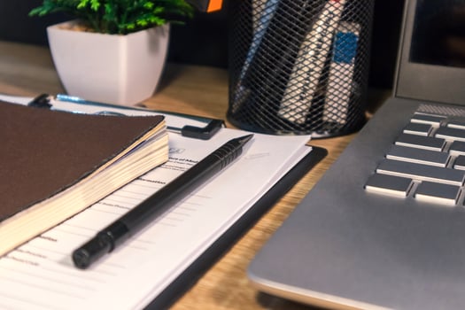 Close up view of workplace with note book, pen, laptop, and stationery photo