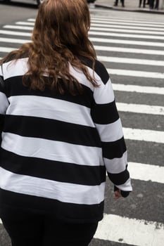 A woman in a striped shirt crossing a street photo
