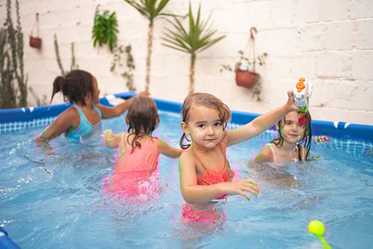 Children enjoying a fun day in a backyard pool under bright sunlight photo