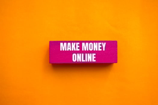 Make money online message written on pink wooden block with orange background. Conceptual make money online symbol. Copy space. photo