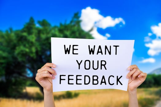 We want your feedback message written on white paper with nature background. Conceptual we want your feedback symbol. Copy space. photo