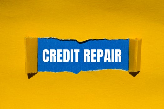 Credit repair message written on ripped torn yellow paper with blue background. Conceptual credit repair symbol. Copy space. photo