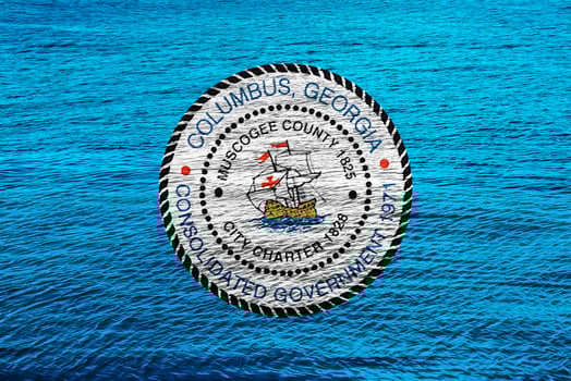 Flag of the city of Columbus, Georgia, USA, on a background of the water surface. Conceptual collage photo