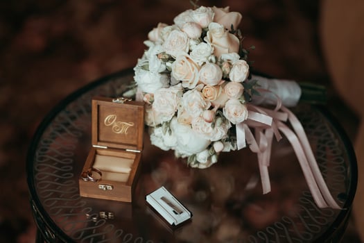 A bouquet of flowers sits on a table next to a wooden box with the letters O photo