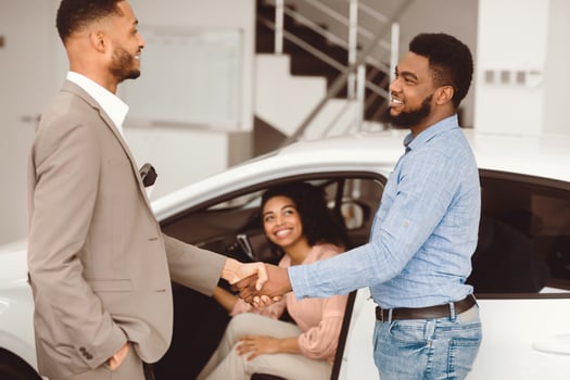 Car Seller Shaking Hands With Buyers After Successful Deal Selling Auto In Dealership Center. Selective Focus photo