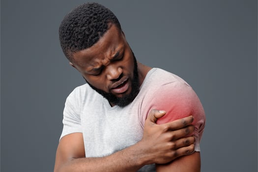 Young afro guy rubbing his itching forearm over white background, having rash photo