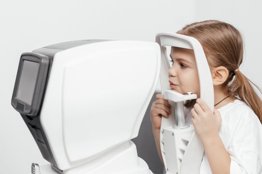 A child being examined with a slit lamp. A device with a microscope and focused light to assess lens and cornea conditions. Perfect for vision diagnostics photo