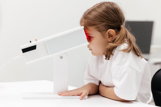 A young girl engages in orthoptic and pleoptic therapy using advanced vision stimulation equipment. Laser eye treatment promotes recovery and enhances vision in a soothing environment photo