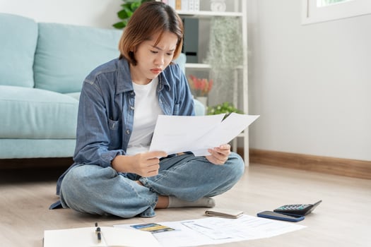 Stressed and headache asian woman with large bills or invoices no money to pay to expenses and credit card debt. shortage, Financial problems, mortgage, loan, bankruptcy, bankrupt, poor, empty wallet photo