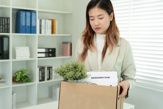 Stressful business women will resign from the company. He is lifting a brown paper box that holds personal items. resignation, job placement and vacancies concept photo