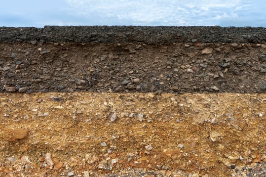 The layer of asphalt road with soil and rock. photo