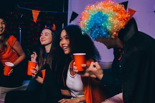 Joyful office Halloween party with coworkers in costumes, celebrating with drinks and laughter, fostering teamwork and festive spirit photo