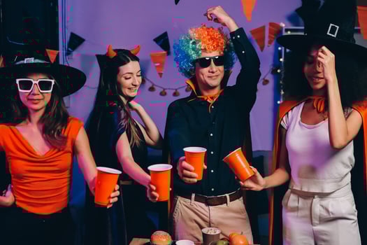 Joyful office Halloween party with coworkers in costumes, celebrating with drinks and laughter, fostering teamwork and festive spirit photo