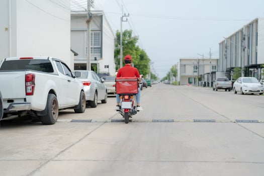 Delivery rider on motorbike in urban setting photo