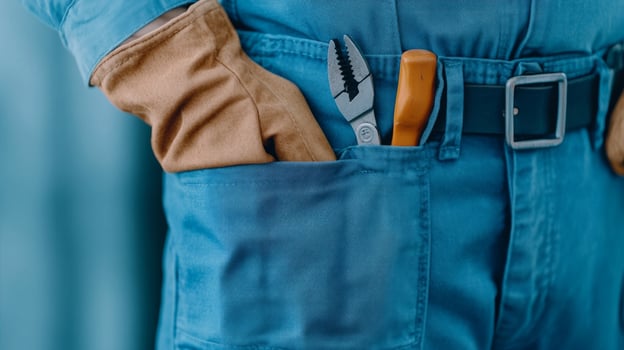 A close-up of a blue-collar workers uniform, featuring tools in the pocket, a leather belt, and protective gloves photo