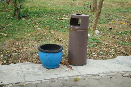 two trash cans made of rubber and metal in a city park photo