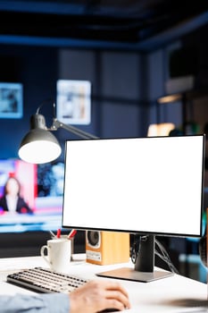 Remote worker looking at white template on pc monitor, sitting at home and using empty computer layout screen. African american freelancer checks isolated blank display at his workstation. photo