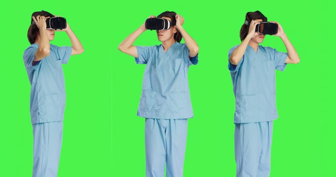 Male nurse using virtual reality glasses against greenscreen template, working with modern interactive 3d headset. Medical healthcare specialist uses artificial intelligence. photo