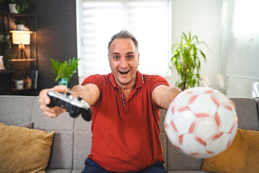 Excited middle-aged man playing games at home photo