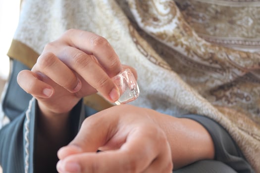 woman rubbing ice cube on his hand. photo