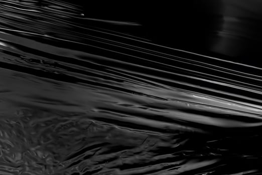 Close-up of abstract black glossy plastic texture with smooth, reflective surface, perfect for backgrounds or design concepts photo