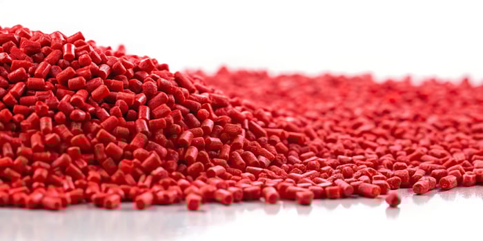 Red plastic polymer granules on white background photo