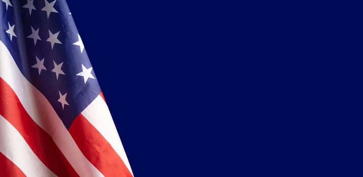 Close-up of the American flag is on the left side on a blue background photo