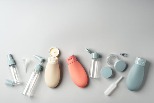 Collection of various reusable cosmetic containers arranged on a light gray background photo