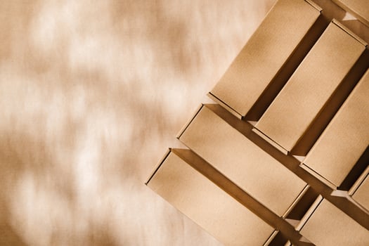 Brown cardboard boxes arranged on a neutral background in a warehouse setting during daylight hours photo